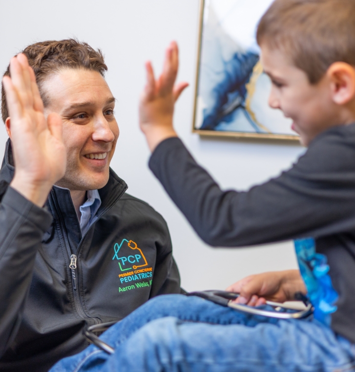 Doctor Weiss giving a high five to a young boy