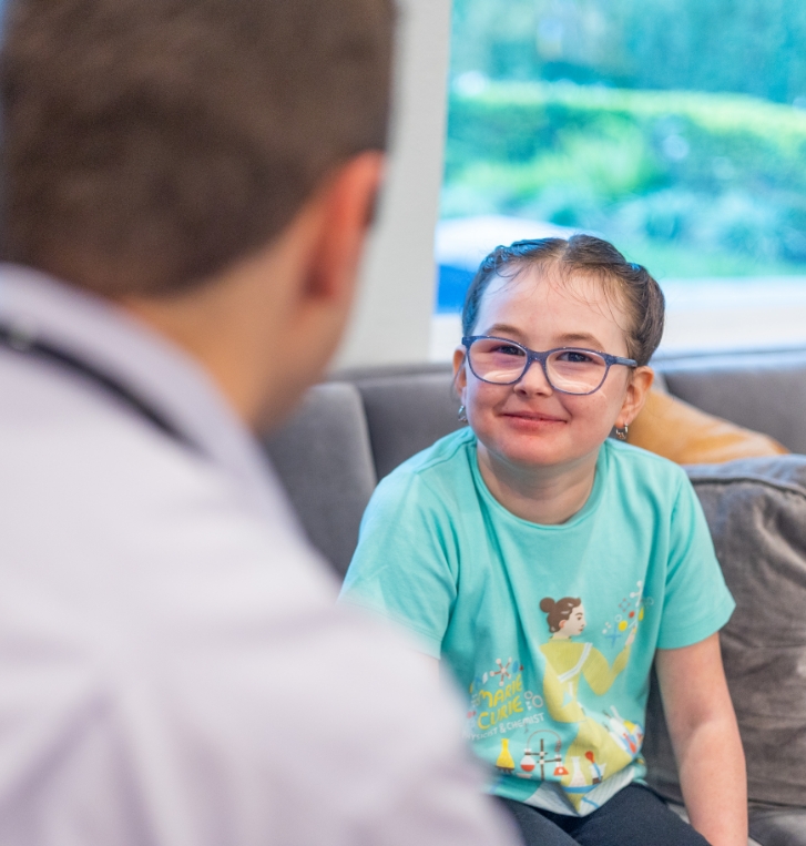 Young girl with glasses smiling at her pediatrician