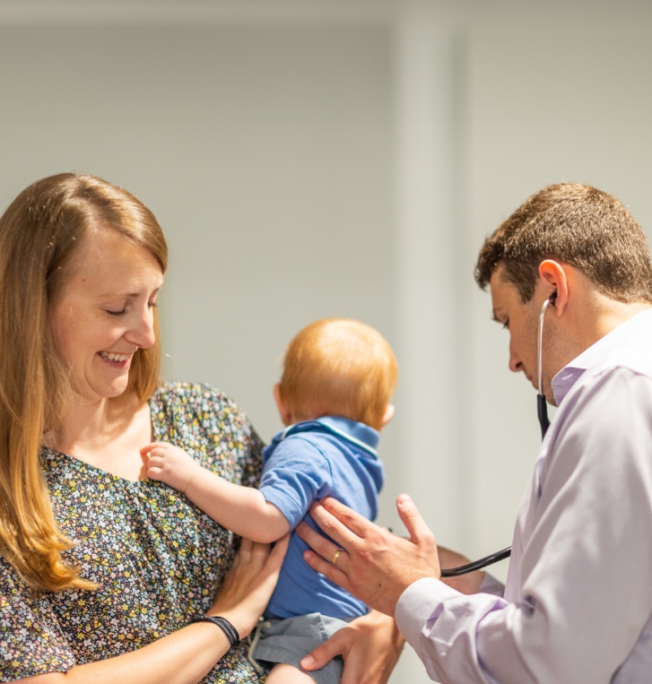 Woman holding her baby during appointment with concierge pediatrician
