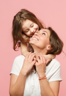 Woman carrying her young daughter on her shoulders