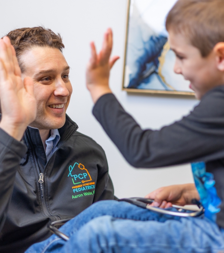 Doctor Weiss giving a high five to a child patient