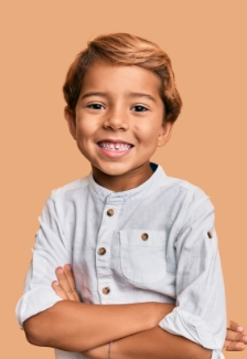 Child smiling with their arms crossed