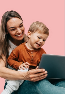 Mother using a tablet with her young son sitting in her lap