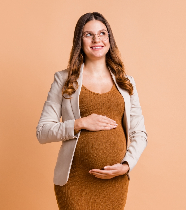 Smiling pregnant woman holding her belly