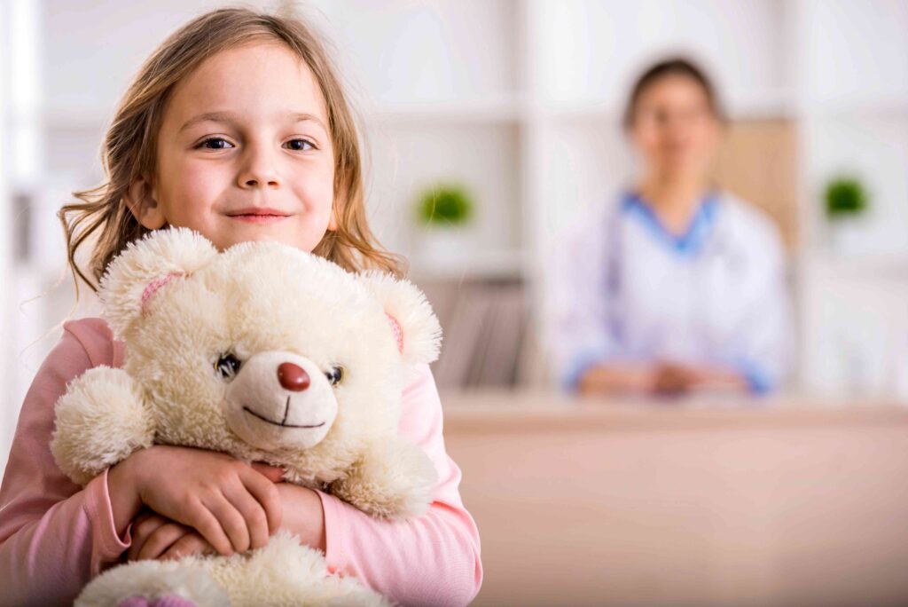 Child holding a teddy bear at the doctor